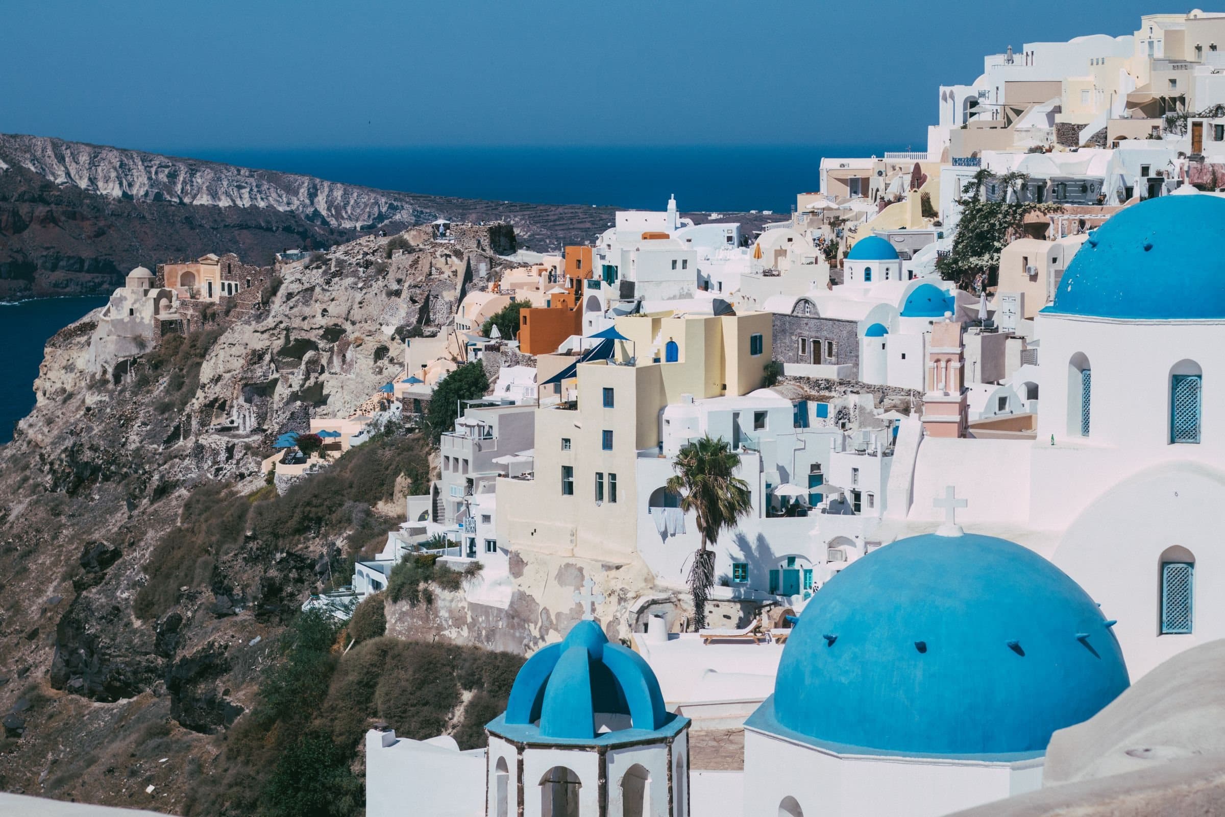 Λευκά σπίτια και γαλάζιος τρούλος πάνω από τη θάλασσα της Σαντορίνης
